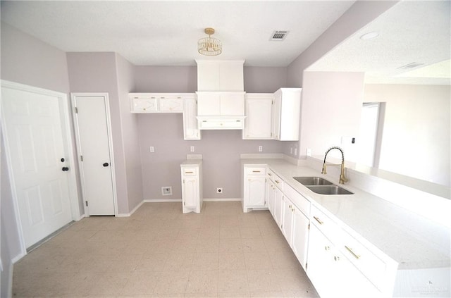 3107 E Laurel St, Hidalgo, TX 78557 - kitchen with a sink, a peninsula, white cabinets, light flooring, and baseboards