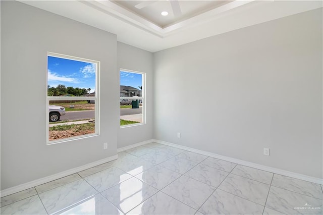 2025 Trinity St, Donna, TX 78537 - unfurnished room featuring light marble finish flooring, baseboards, ceiling fan, and a raised ceiling