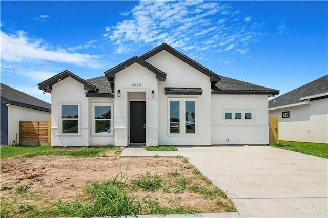 2025 Trinity St, Donna, TX 78537 - view of front facade with stucco siding, driveway, and a shingled roof
