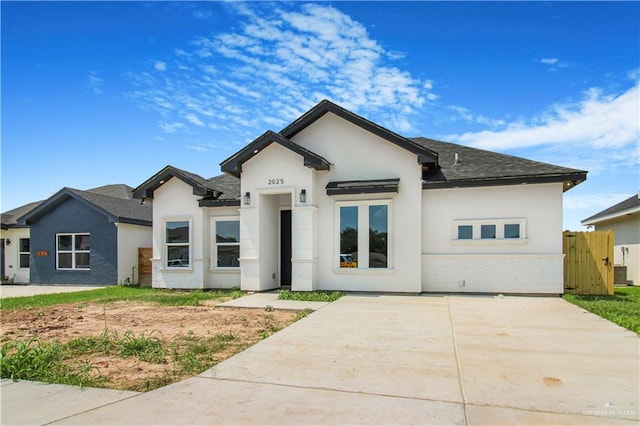 2025 Trinity St, Donna, TX 78537 - view of front of property featuring a shingled roof, stucco siding, and cooling unit