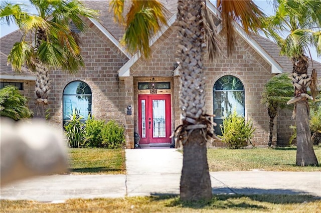 property entrance with a lawn