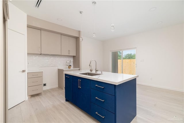 2711 Harmony St, Mission, TX 78574 - kitchen with light wood-type flooring, a sink, backsplash, and light countertops