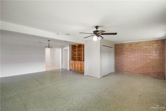 206 E Ricky Crossland Ave, Elsa, TX 78543 - spare room featuring brick wall, a ceiling fan, and a chandelier