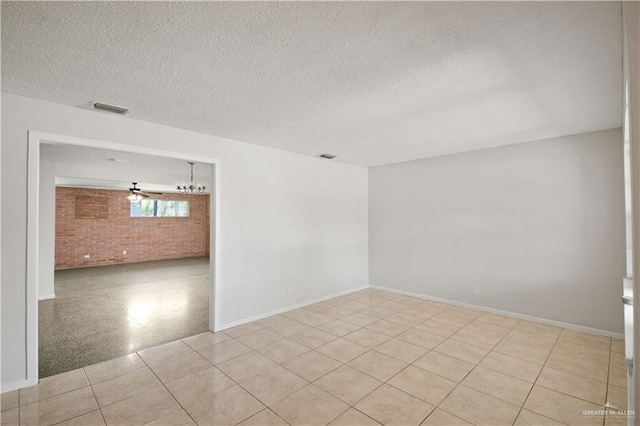 206 E Ricky Crossland Ave, Elsa, TX 78543 - empty room featuring a textured ceiling and brick wall