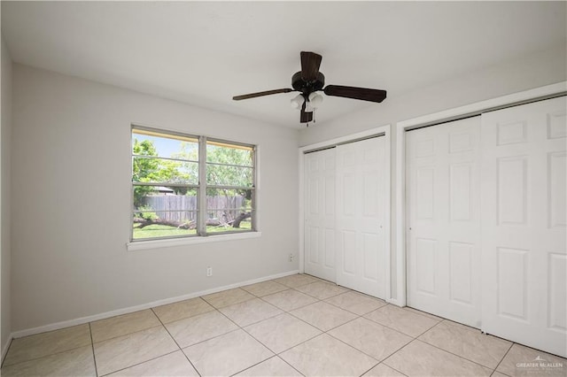 206 E Ricky Crossland Ave, Elsa, TX 78543 - unfurnished bedroom with multiple closets, light tile patterned floors, and a ceiling fan