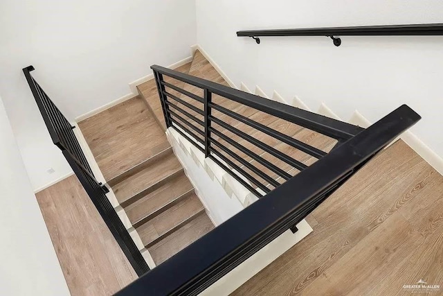 stairway featuring baseboards and wood finished floors