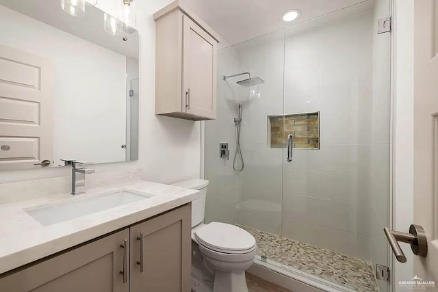 bathroom featuring vanity, recessed lighting, toilet, and a shower stall