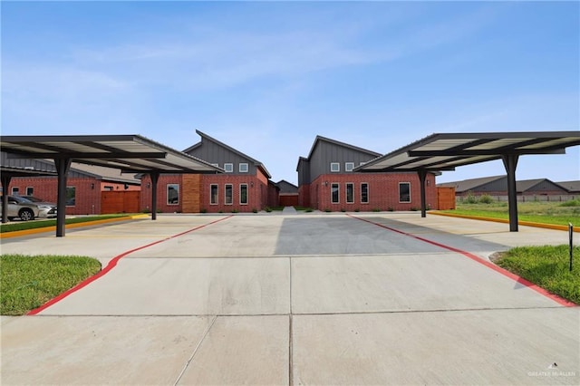 exterior space with board and batten siding, fence, and covered parking