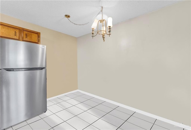 1700 E 23rd St Unit 15, Mission, TX 78574 - unfurnished dining area with a chandelier, light tile patterned floors, and a textured ceiling