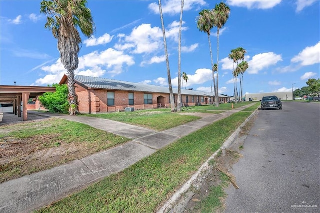 1700 E 23rd St Unit 15, Mission, TX 78574 - view of front of property with brick siding, a metal roof, and a front lawn