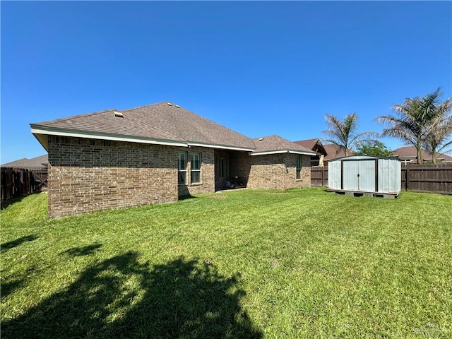 rear view of house with a storage shed and a yard