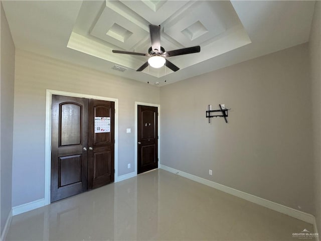 interior space featuring a raised ceiling and ceiling fan