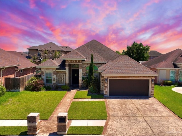 view of front of property with a garage and a yard