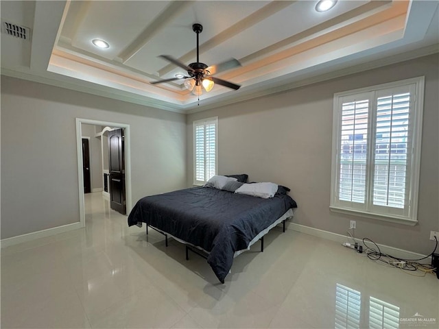 tiled bedroom featuring ceiling fan, a raised ceiling, and ornamental molding