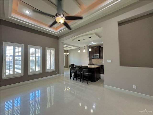 dining room with ceiling fan with notable chandelier, a raised ceiling, and crown molding