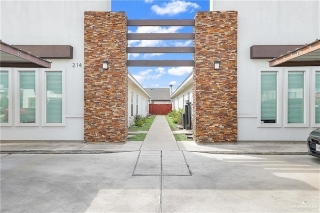 view of side of property featuring fence and stucco siding