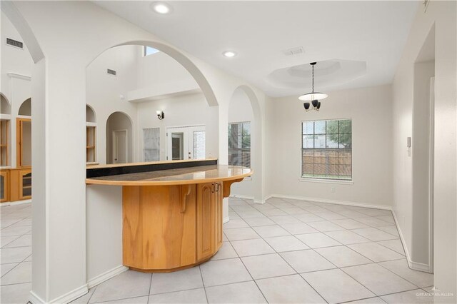 kitchen with light tile patterned floors and pendant lighting