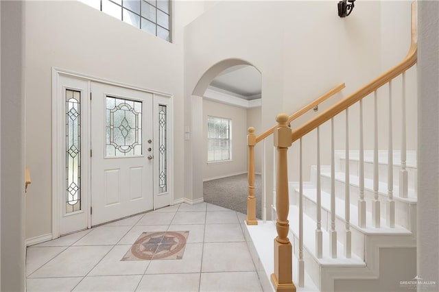 entrance foyer with light tile patterned floors and a towering ceiling