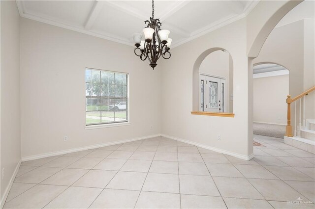 spare room with light tile patterned flooring, ornamental molding, coffered ceiling, and a notable chandelier