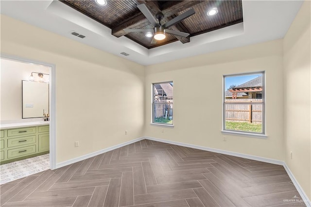 empty room featuring parquet flooring, a raised ceiling, ceiling fan, beam ceiling, and wooden ceiling