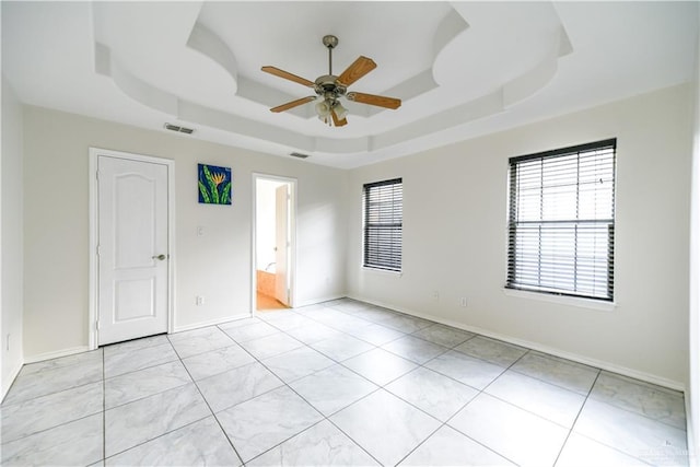 2121 Kingsborough Ave, Mcallen, TX 78504 - empty room with a ceiling fan, a tray ceiling, and baseboards
