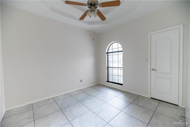 2121 Kingsborough Ave, Mcallen, TX 78504 - spare room with a ceiling fan, a tray ceiling, light tile patterned floors, and baseboards