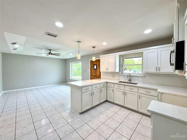 kitchen with recessed lighting, a sink, light tile patterned flooring, visible vents, and a peninsula