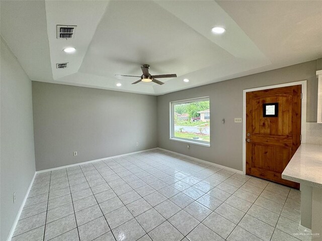 unfurnished room featuring recessed lighting, visible vents, a ceiling fan, light tile patterned flooring, and a tray ceiling