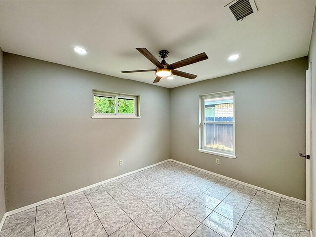 empty room featuring recessed lighting, a ceiling fan, visible vents, and plenty of natural light