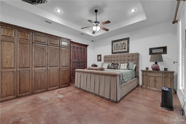 bedroom with ceiling fan and a raised ceiling