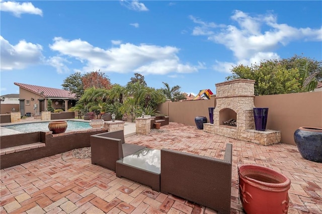 view of patio with a fenced in pool and an outdoor stone fireplace