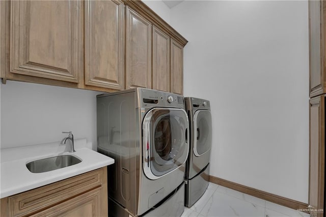 clothes washing area featuring cabinets, washing machine and dryer, and sink