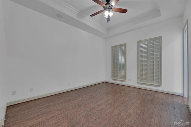 spare room with dark hardwood / wood-style flooring, ceiling fan, a raised ceiling, and crown molding