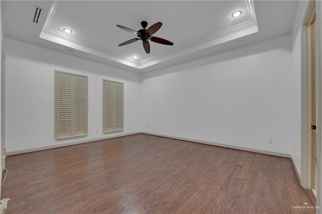 empty room with hardwood / wood-style floors, a raised ceiling, ceiling fan, and crown molding