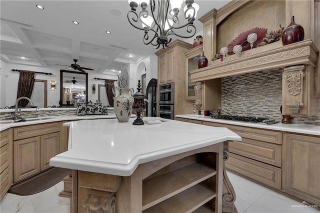 kitchen with tasteful backsplash, coffered ceiling, gas stovetop, sink, and beam ceiling