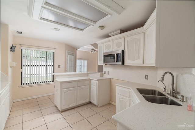 3512 W Gardenia Ave, Mcallen, TX 78501 - kitchen featuring stainless steel microwave, light tile patterned floors, ceiling fan, a sink, and visible vents