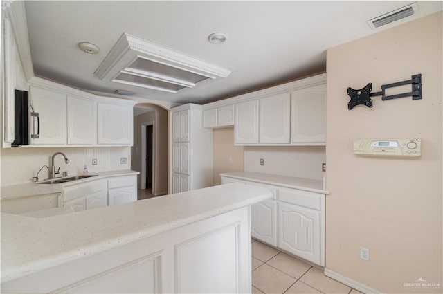 3512 W Gardenia Ave, Mcallen, TX 78501 - kitchen featuring arched walkways, light tile patterned floors, a sink, visible vents, and a peninsula