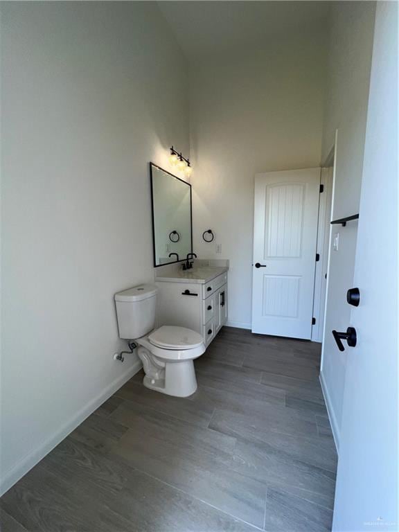 bathroom with vanity, wood-type flooring, and toilet