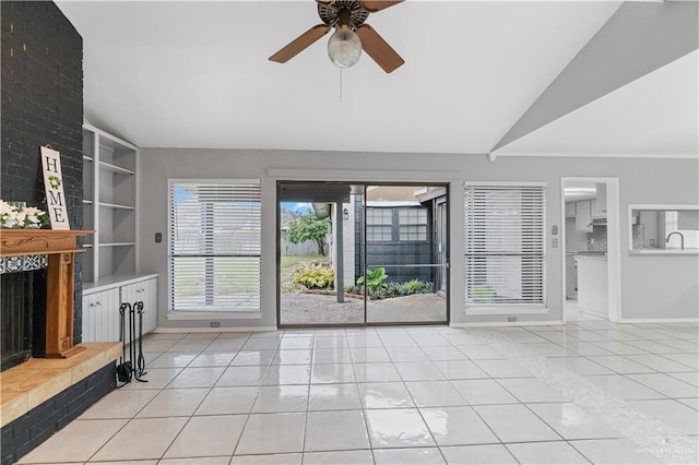 living room featuring ceiling fan, light tile patterned floors, a fireplace, and vaulted ceiling