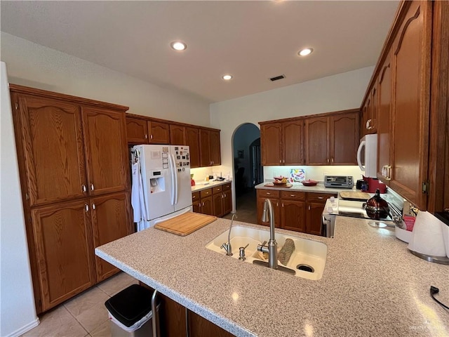 233 Karen Dr, Alamo, TX 78516 - kitchen featuring white appliances, arched walkways, light countertops, a peninsula, and recessed lighting