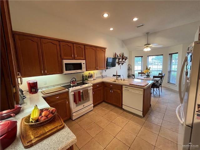 233 Karen Dr, Alamo, TX 78516 - kitchen featuring white appliances, a peninsula, light countertops, recessed lighting, and vaulted ceiling