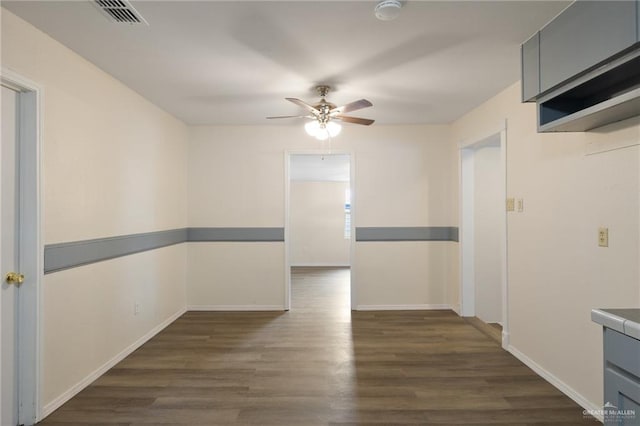 empty room featuring ceiling fan and dark wood-type flooring