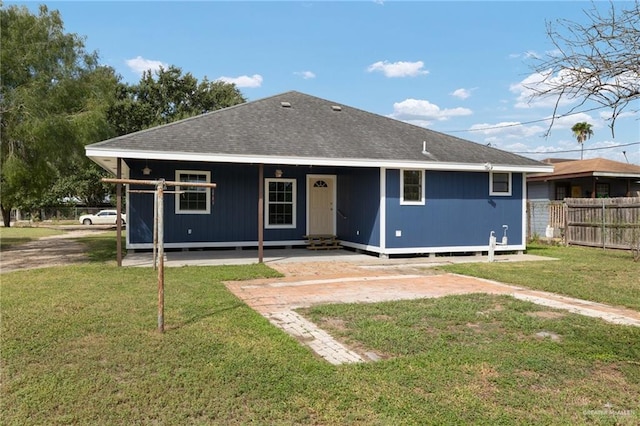 rear view of house featuring a lawn