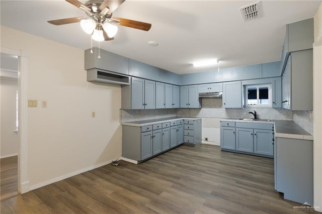 kitchen featuring dark hardwood / wood-style floors, ceiling fan, decorative backsplash, and sink