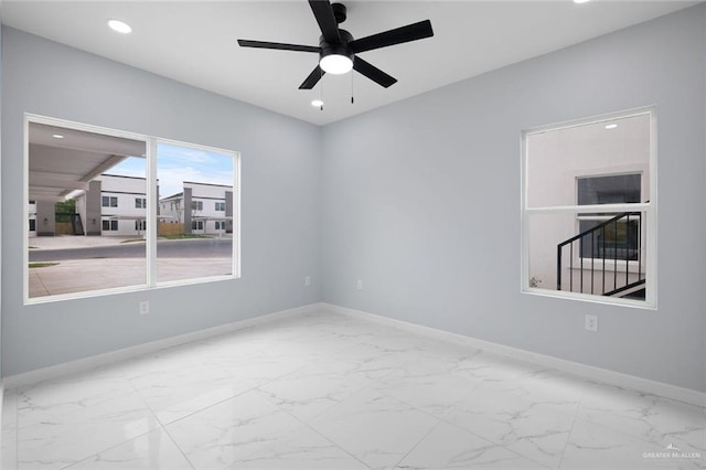 empty room featuring marble finish floor, a ceiling fan, baseboards, and recessed lighting