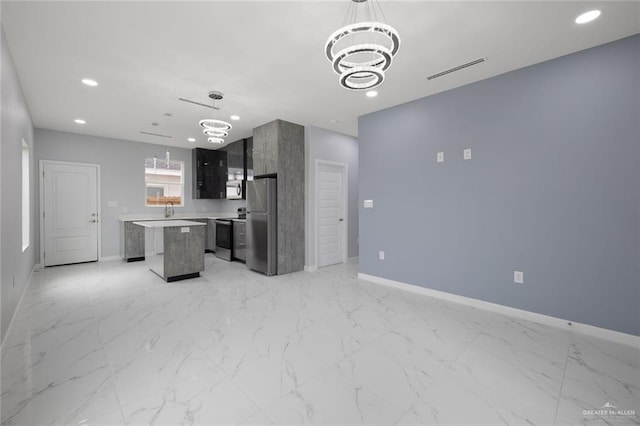 kitchen with stainless steel appliances, a center island, baseboards, a chandelier, and light countertops