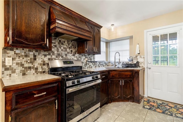 1123 E Champion St, Edinburg, TX 78539 - kitchen featuring gas range, extractor fan, light tile patterned floors, tasteful backsplash, and dark brown cabinets