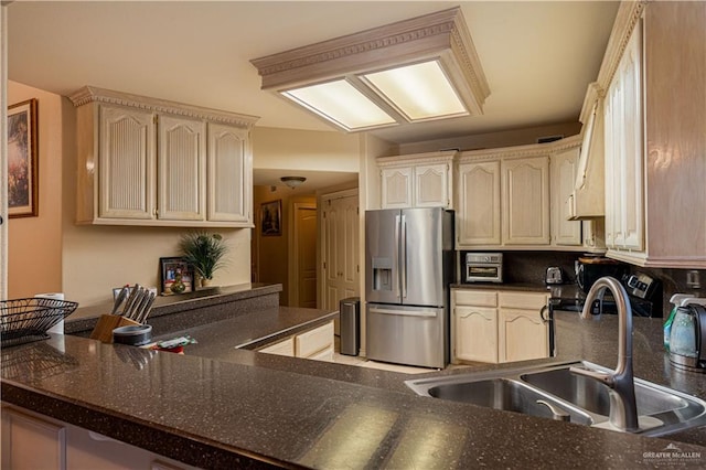 kitchen with backsplash, kitchen peninsula, stainless steel fridge with ice dispenser, and sink