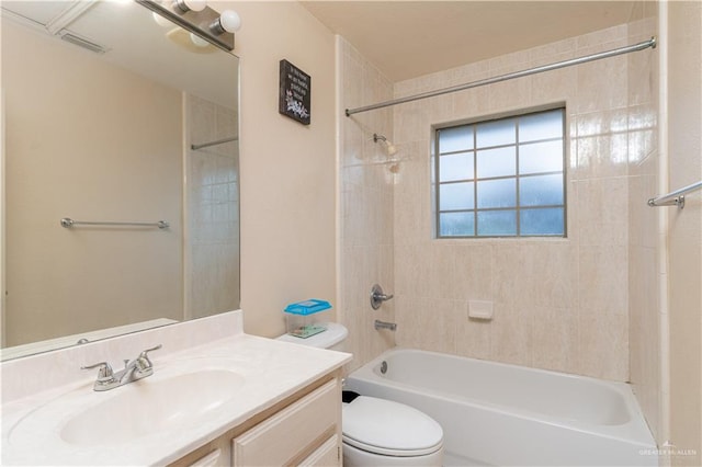 full bathroom with vanity, tiled shower / bath combo, and toilet