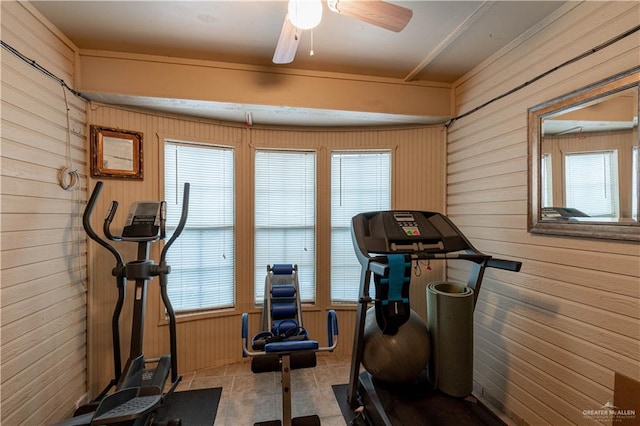 exercise area with wood walls and ceiling fan